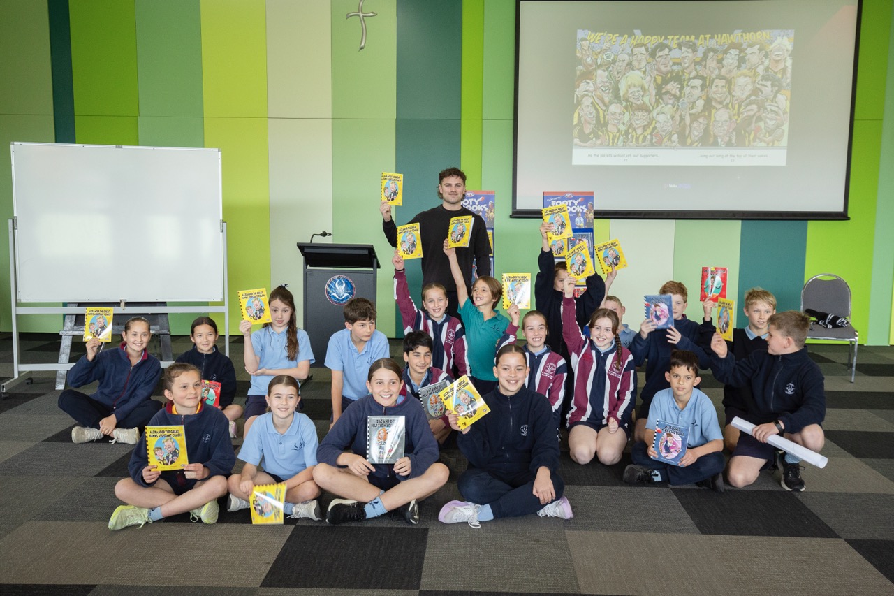 Primary school students reading Fantastic Footy Books